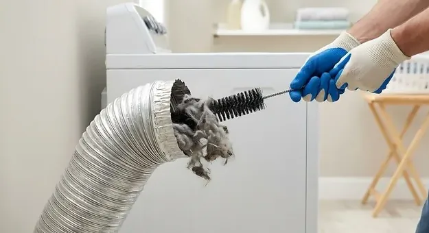 Brush pulling packed lint out of a dryer duct